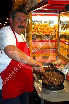 Argentine street vendor making toffee covered nuts at Necochea, Argentina.