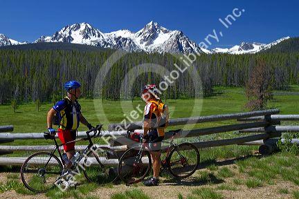 Touring bicyclists stop for a view of the Sawtooth Mountain Range near Stanley, Idaho, USA.