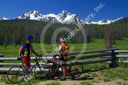 Touring bicyclists stop for a view of the Sawtooth Mountain Range near Stanley, Idaho, USA.