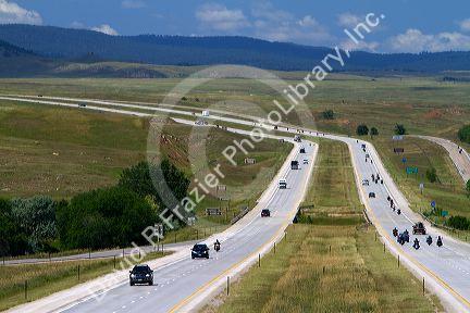 Motorcycles and automobiles travel on I-90 during Sturgis Motorcycle rally week west of Spearfish, South Dakota, USA.