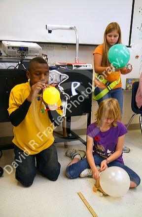 Students blowing up balloons as part of a science experiment in a fourh grade classroom at a public elementary school in Brandon, Florida, USA.