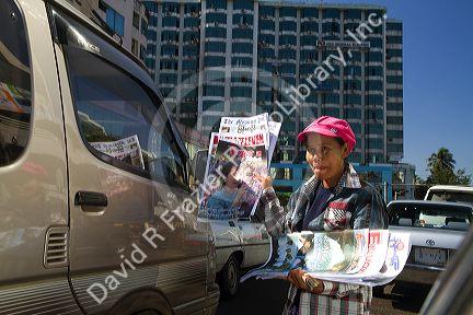 Burmese woman standing in traffic selling newspapers in (Rangoon) Yangon, (Burma) Myanmar.