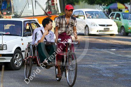 Passengers riding in a trishaw in (Rangoon) Yangon, (Burma) Myanmar.