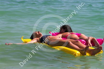 Girls float on air matresses in the Gulf of Thailand at Chaweng beach on the island of Ko Samui, Thailand.