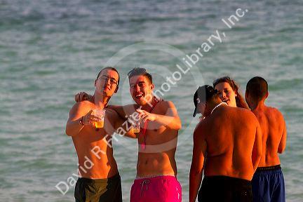 Young beach goers drink beer at Chaweng beach in the Gulf of Thailand on the island of Ko Samui, Thailand.