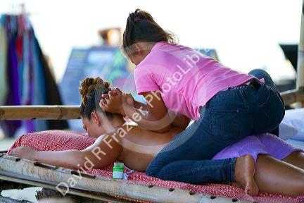 Woman receiving a Thai massage at Chaweng beach on the island of Ko Samui, Thailand.