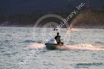 Man riding a personal water craft in the Gulf of Thailand at Chaweng beach on the island of Ko Samui, Thailand.