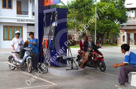 Motor scooters fill up at a gas station on the island of Ko Samui, Thailand.