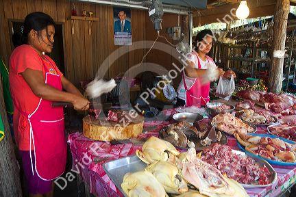 Women chopping and selling meat at an open air market on the island of Ko Samui, Thailand.