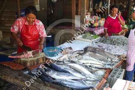 Vendor selling fresh fish at an open air market on the island of Ko Samui, Thailand.