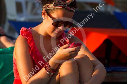 Woman using a smart phone at Chaweng beach on the island of Ko Samui, Thailand.