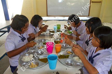 Thai elementary school students eat lunch on the island of Ko Samui, Thailand.