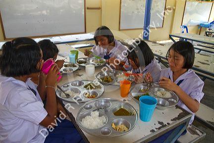 Thai elementary school students eat lunch on the island of Ko Samui, Thailand.