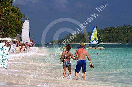 People walk hand in hand along the Gulf of Thailand at Chaweng beach on the island of Ko Samui, Thailand.