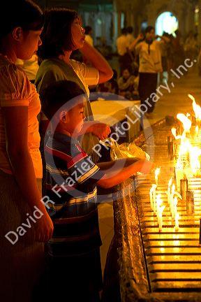 A young boy lighting a candle at the Shwedagon Paya located in (Rangoon)Yangon, (Burma) Myanmar.
