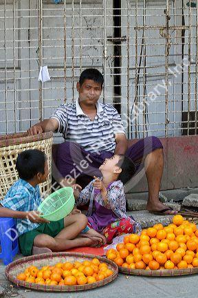 Burmese father and sons selling oranges on the street in (Rangoon) Yangon, (Burma) Myanmar.