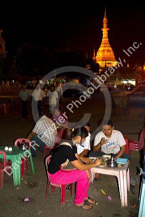 Burmese people eat and drink outdoors near the Sule Paya located in the heart of downtown (Rangoon) Yangon, (Burma) Myanmar.