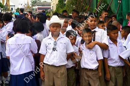 Thai school students wearing uniforms visit The Grand Palace in Bangkok, Thailand.