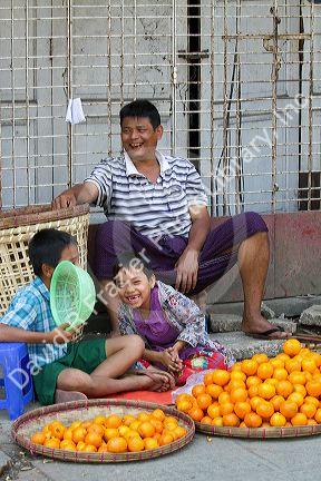 Burmese father and sons selling oranges on the street in (Rangoon) Yangon, (Burma) Myanmar.