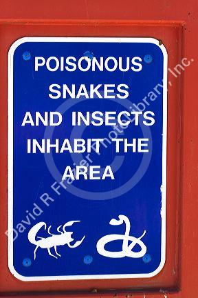 Sign warning of poisonous snakes and insects at a rest area along Interstate 10 in southern Arizona, USA.
