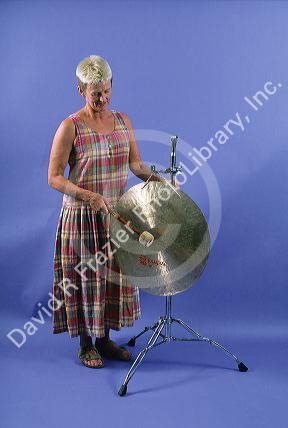 A woman playing a gong.