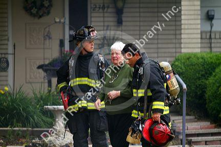 Firefighters assist a resident during a house fire in Boise, Idaho, USA.