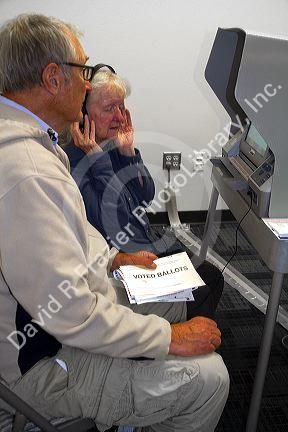 Visually impared woman using a headset for voting assistance at a polling station in Boise, Idaho, USA.