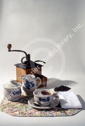 An old fashioned coffee grinder and serving dishes.