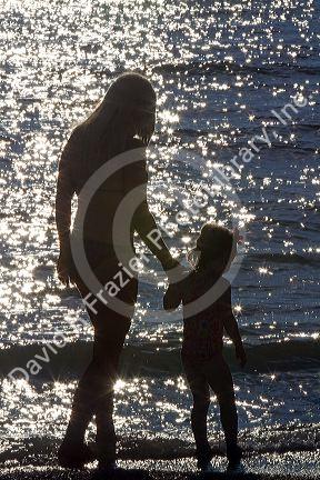 Mother and daughter holding hands at the beach on the coast of Florida, USA. MR
