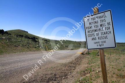 Road sign warning of search and rescue costs for traveling on unimproved road in Owyhee County, Idaho, USA.