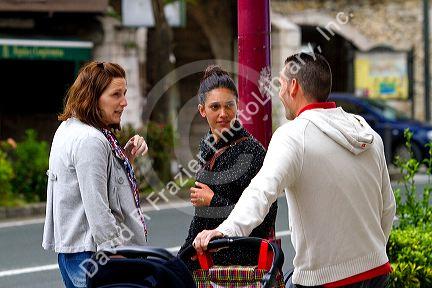 People talk on the street in San Vicente de al Barquera, Cantabria, Spain.