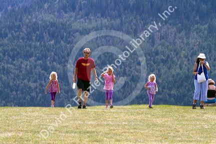 Family of tourists walking on a hillside in Waterton Lakes National Park, Alberta, Canada.