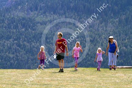 Family of tourists walking on a hillside in Waterton Lakes National Park, Alberta, Canada.