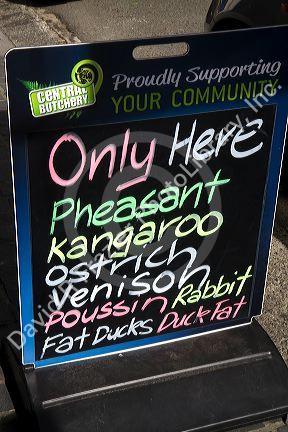Menu board advertising exotic meats available at a butcher shop in the town of Kawakawa, North Island, New Zealand.