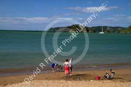 People on the beach at Bay of Islands at the town of Paihia, North Island, New Zealand.