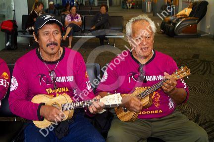 Tahitian men play ukulele at the Auckland Airport, Auckland, North Island, New Zealand.