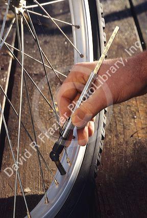 Air pressure gauge being used on a bicycle tire.