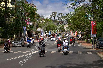 People riding scooters on the street in Da Lat, Vietnam.