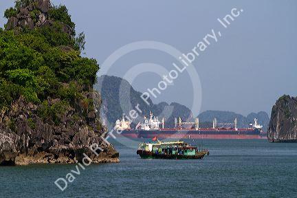 House boats and container ships in Ha Long Bay, Vietnam.