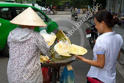 Vietnamese street vendor selling durian fruit in Hanoi, Vietnam.