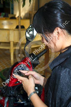 Vietnamese woman using an iphone in Nha Trang, Vietnam.