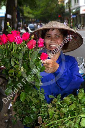 Vietnamese street vendor selling roses in Hanoi, Vietnam.