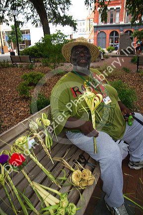 African american man selling river street roses weaved from palm fronds in Savannah, Georgia, USA.