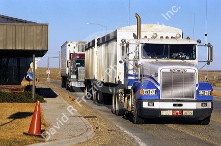 Long haul trucks line up a weigh station.