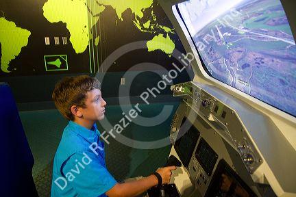 Boy using a flight simulator at the John F. Kennedy Space Center, Merritt Island, Florida, USA.