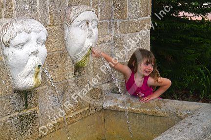 Five year old girl playing in a water fountain at St. Augustine, Florida, USA