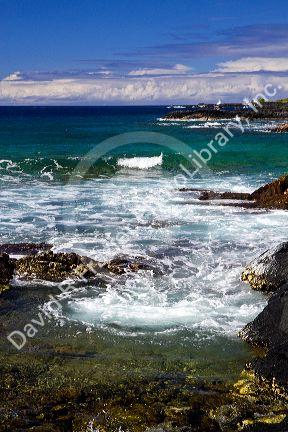 Waves crash along the rocky coast at Kailua-Kona on the Big Island of Hawaii, USA.