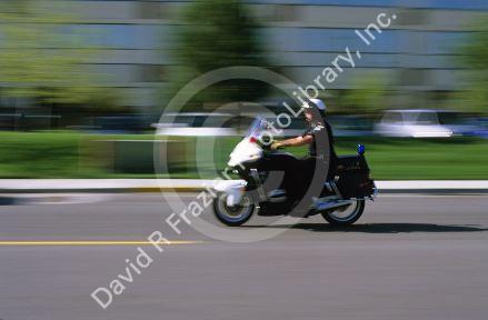 A police officer on a motorcycle in motion.