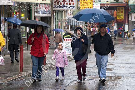 People walking in the rainwith umbrellas in Chinatown, San Francisco, California.