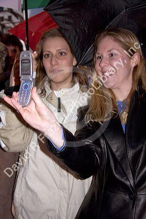 Women using a camera cell phone to take photos of the Chinese New Year Parade, Chinatown, San Francisco, California.